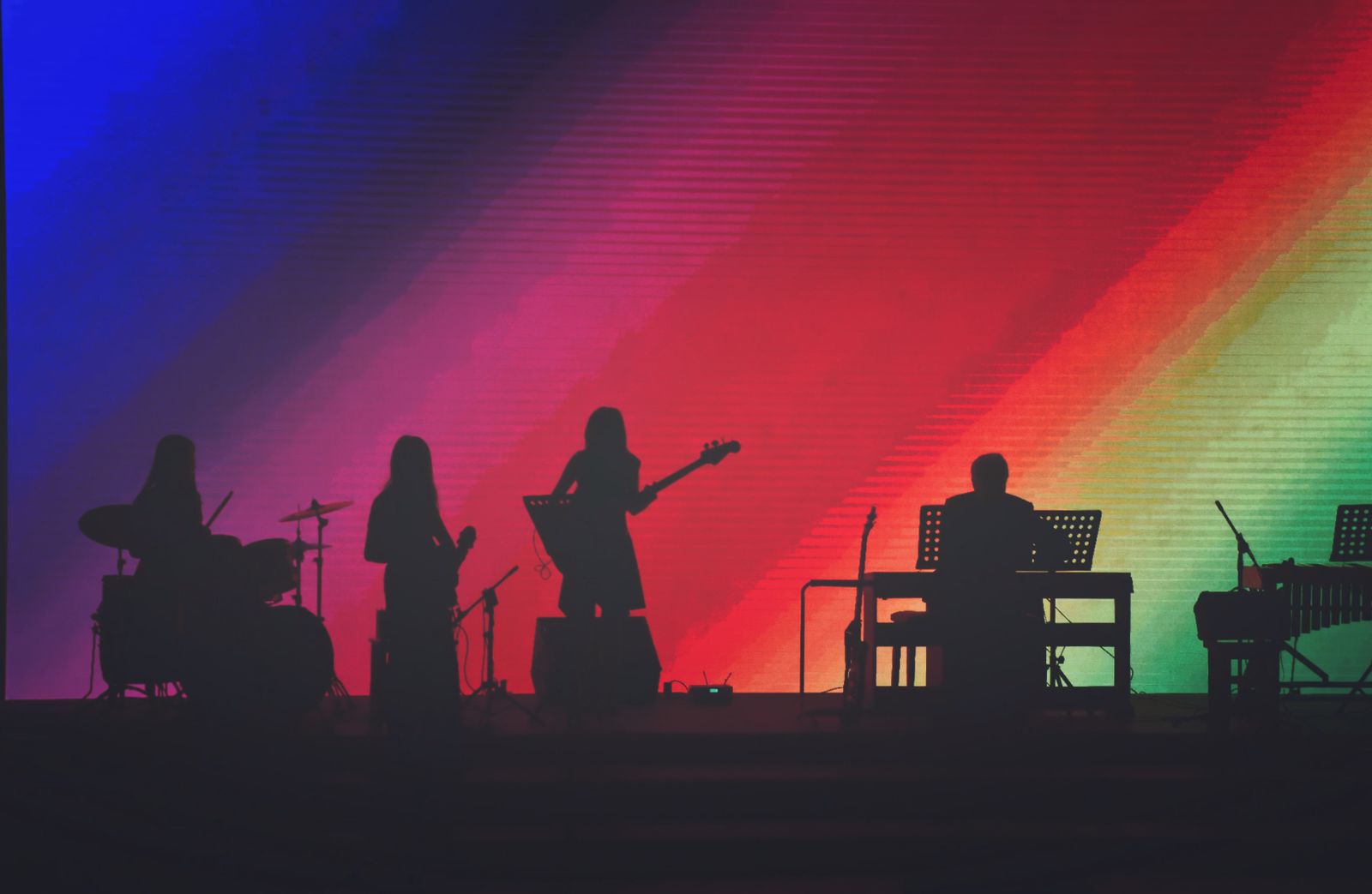 Diverse band of musicians playing instruments together on stage